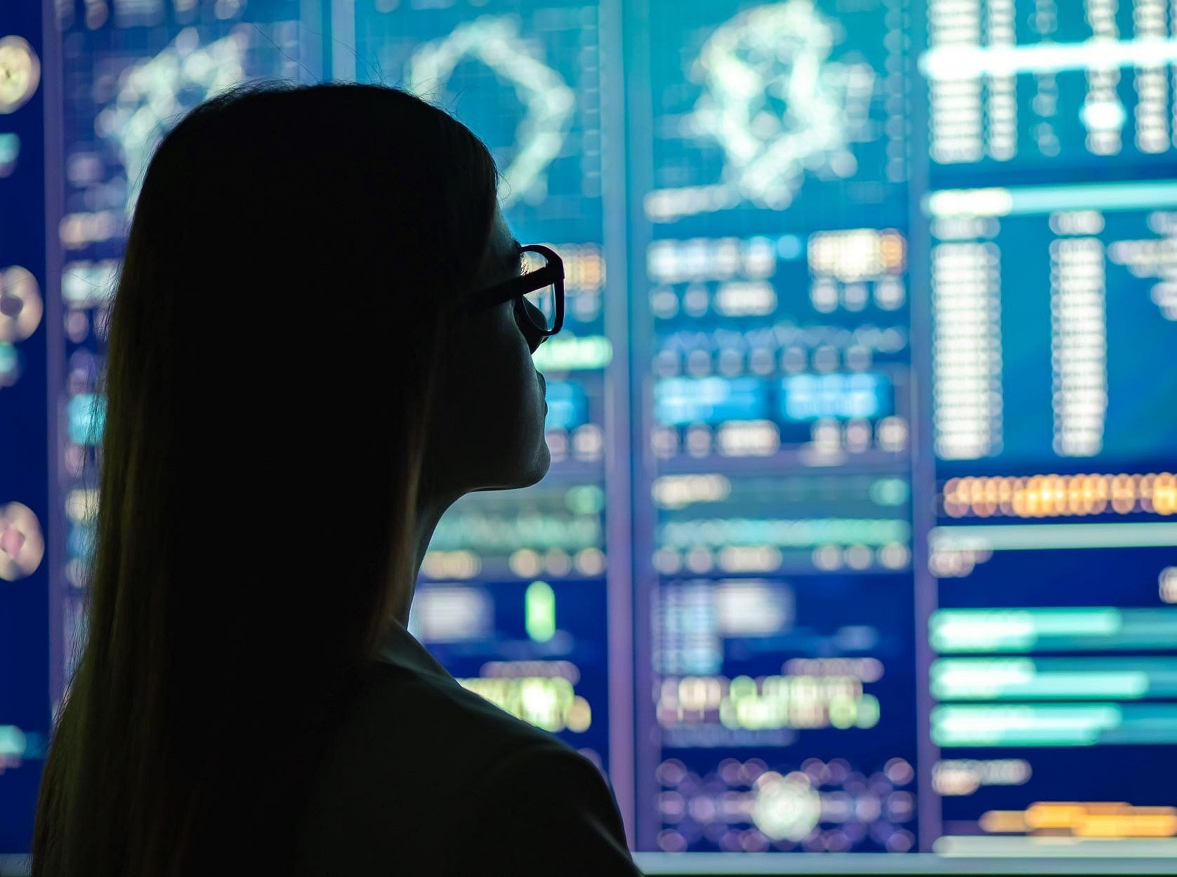 Woman in dark looking at statistics