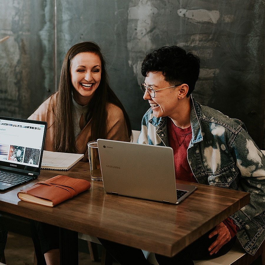 Man and woman in a cafe using computers